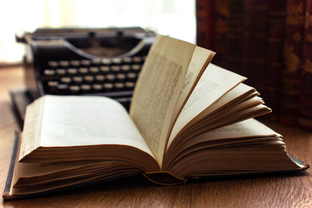 istock Old vintage book with backlight and and old typewriter in the background bibliography literature concept 1139147429