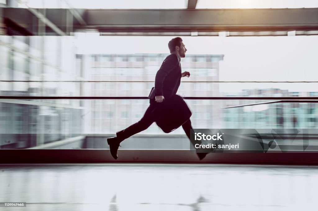 Businessman Running Along The Corridor Businessman Running Across The Corridor Urgency Stock Photo