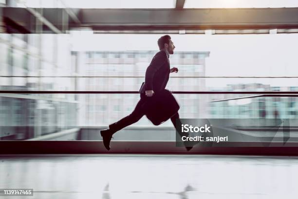 Businessman Running Along The Corridor Stock Photo - Download Image Now - Urgency, Running, Business