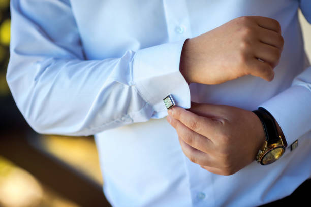 Businessman puts on cufflinks. Groom getting ready in the morning before wedding ceremony