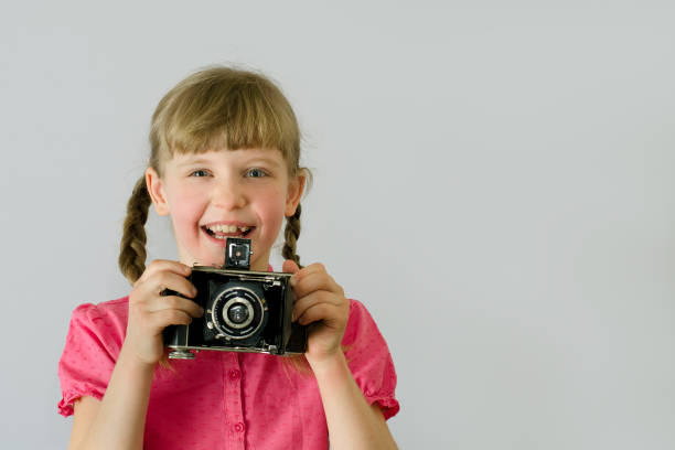 istock little girl (kid, child) with an old camera 1139151245