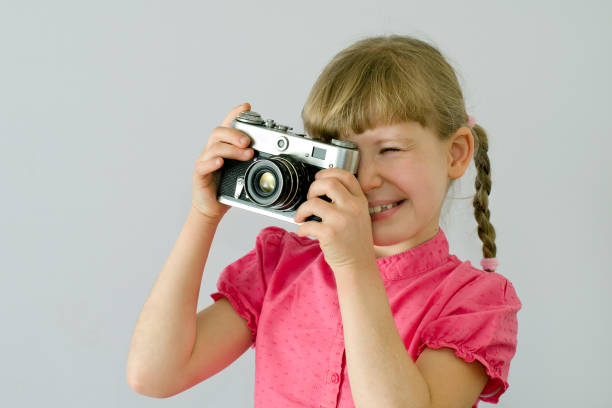 istock kid, child takes pictures with an old camera 1139151257