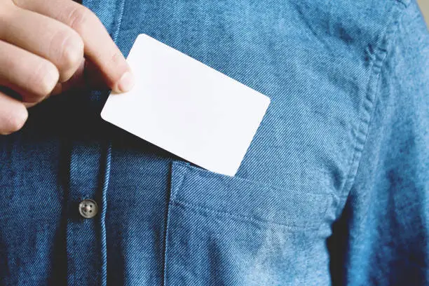 Photo of Young man is taking a blank card in the pocket of his shirt.