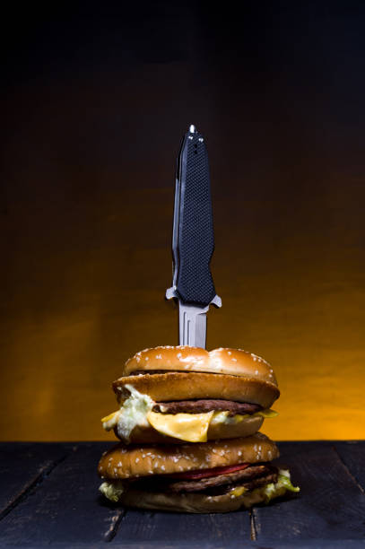 istock The knife is embedded in a burger. Hunting knife in a burger. 1139156896