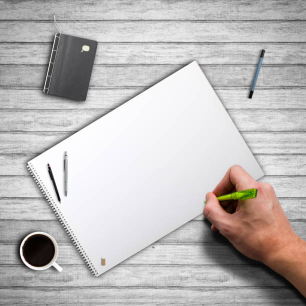 istock hand starting to write on empty notepad on wooden background 1139164347