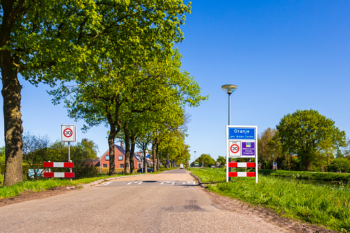 Roadsign to welcome visitors and tourism to the small village Oranje, Drenthe, the Netherlands. Warm sunny day with clear bue sky.