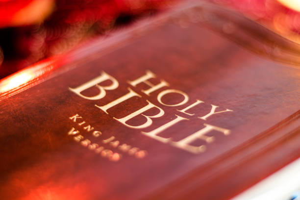 istock Holy Bible with pressed decorative leather cover on table with soft flickering candlelight 1139167576