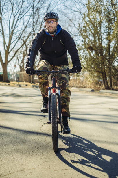 hombre caucásico en bicicleta en el parque - ontario spring bicycle city life fotografías e imágenes de stock