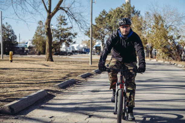 hombre caucásico en bicicleta en el parque - ontario spring bicycle city life fotografías e imágenes de stock