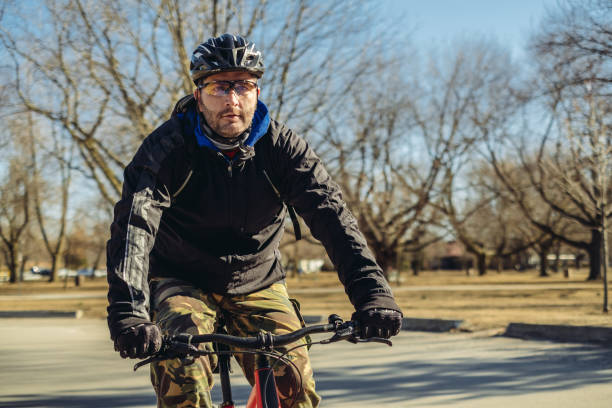 hombre caucásico en bicicleta en el parque - ontario spring bicycle city life fotografías e imágenes de stock