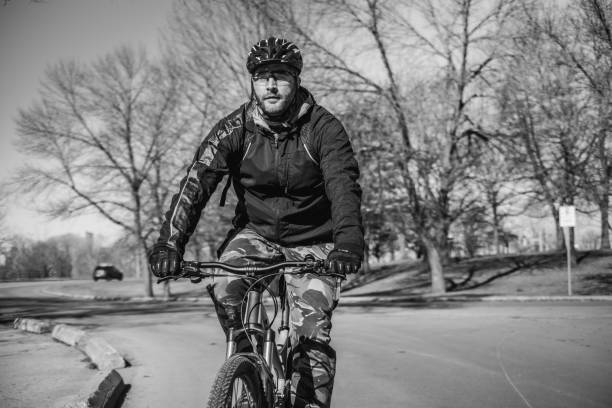 caucasian man biking in city park - ontario spring bicycle city life imagens e fotografias de stock