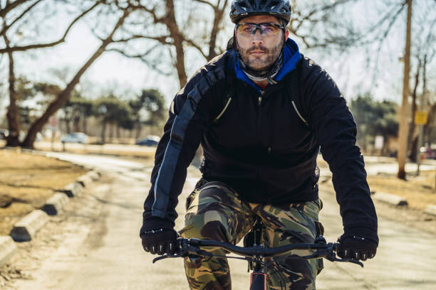 homme caucasien faisant du vélo dans le parc de ville - ontario spring bicycle city life photos et images de collection