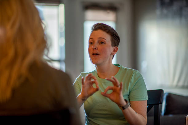 deaf woman signs to her partner - sign language imagens e fotografias de stock