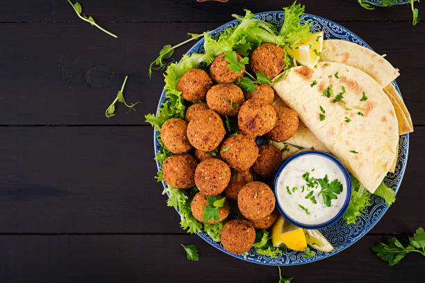 Falafel, hummus and pita. Middle eastern or arabic dishes on a dark background. Halal food. Top view. Copy space stock photo