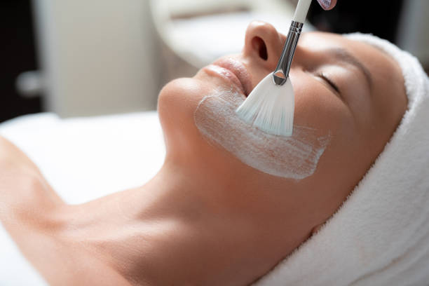 beautician hand applying mask on lady face using cosmetic brush - beautician body care relaxation luxury imagens e fotografias de stock