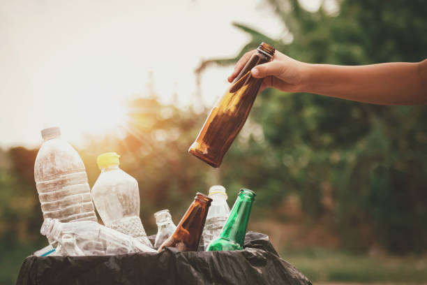 istock hand holding garbage bottle glass putting into recycle bag for cleaning 1139199640