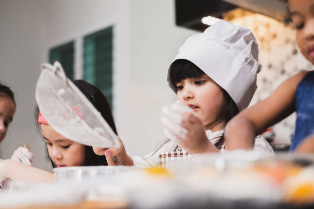 istock Group diversity kids girl making cake bakery in kitchen 1139205954