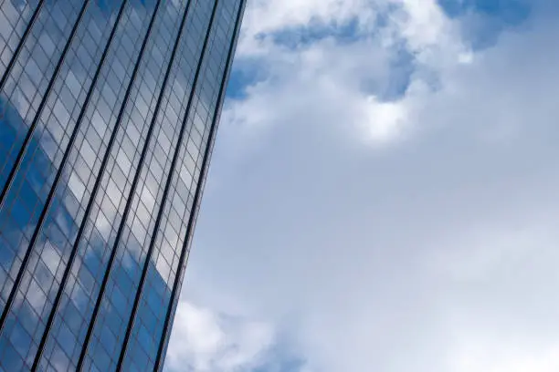 Photo of Industrial business building glass reflecting blue sky and clouds on a new york city day