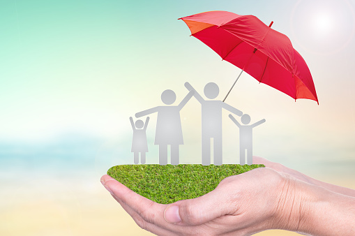 Life insurance concept of family on hands of insurance agent  to protection by umbrella.