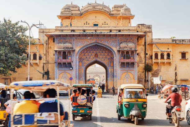Awesome view of scenic gate at Gangori Bazaar, Jaipur, India Jaipur, India - 11 November, 2018: Awesome view of scenic gate on Tulsi Marg at Gangori Bazaar. Tourists and residents walking along the Old Pink City. Day traffic. Cars, motorbikes and auto rickshaws jaipur photos stock pictures, royalty-free photos & images