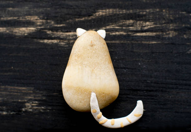 little cat, handmade by myself with pebble and clay, on weathered wooden table