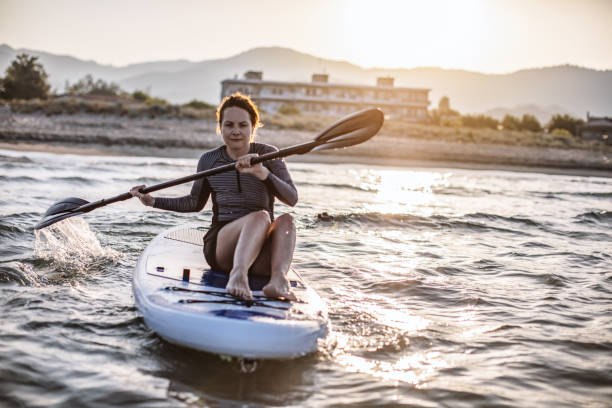 istock Woman in wetsuit with a paddle board 1139221564