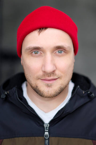istock A young man in casual clothes and a red hat on a dark background. 1139221778