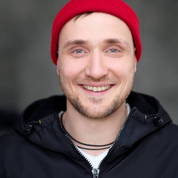 istock A young man in casual clothes and a red hat on a dark background. 1139221798