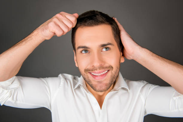 istock Handsome cheerful young man combing his hair 1139226364