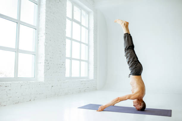 istock Senior man practising yoga indoors 1139227538