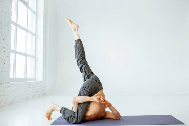 istock Senior man practising yoga indoors 1139227546