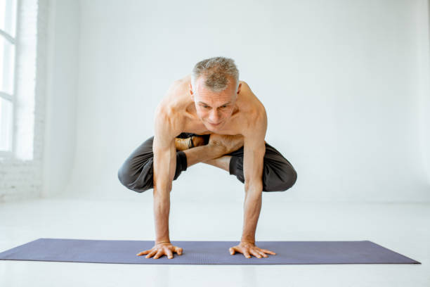 istock Senior man practising yoga indoors 1139227560