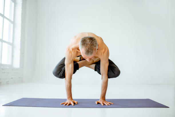 istock Senior man practising yoga indoors 1139227562