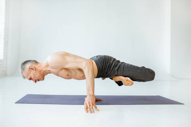 istock Senior man practising yoga indoors 1139227567