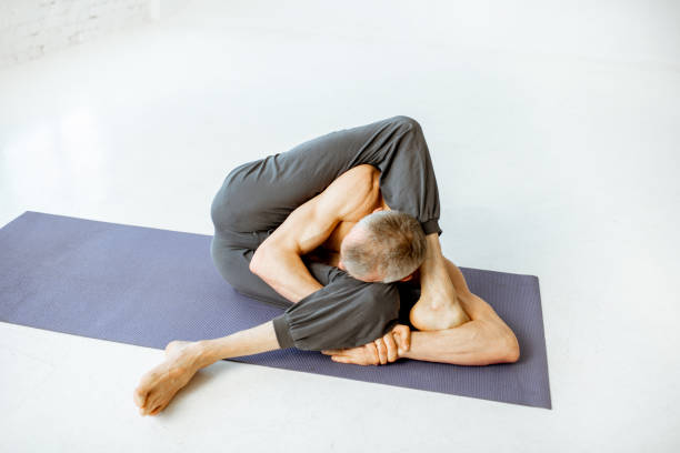 istock Senior man practising yoga indoors 1139227569