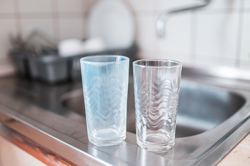 Vasos de cristal sucios y limpios en un fregadero de la cocina. Concepto de lavadora rota. photo