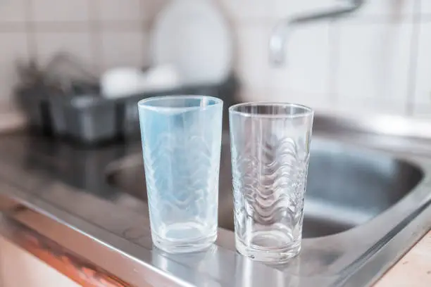 Photo of Dirty and clean glass cups on a kitchen sink. Broken washing machine concept.