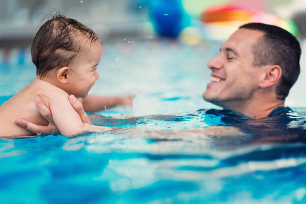 istock Smiling Father And Son Swimming In Pool 1139234404