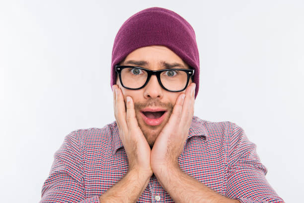 istock Surprised man in hat and glasses touching his face 1139236037