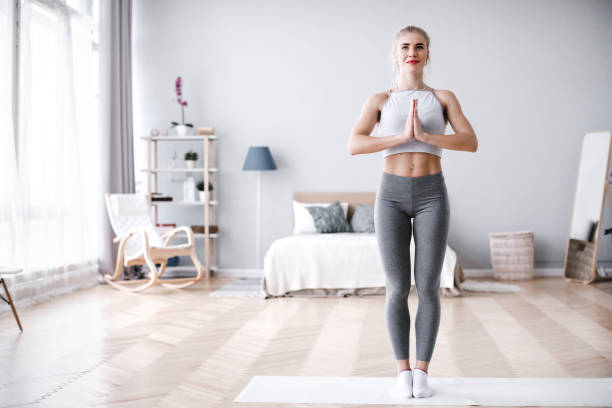 istock Young woman doing yoga at home, tree pose. 1139238394