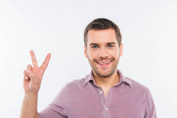 istock Cheerful young man gesturing with two fingers 1139238433