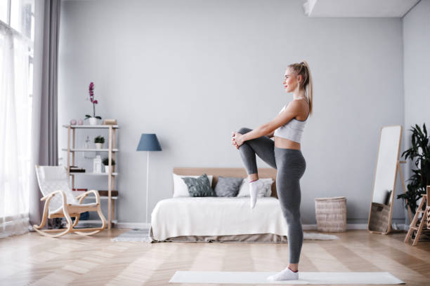 Full length portrait of attractive young woman working out at home, doing pilates exercise on mat. Full length portrait of attractive young woman working out at home, doing pilates exercise on mat. Training indoor. home workout stock pictures, royalty-free photos & images