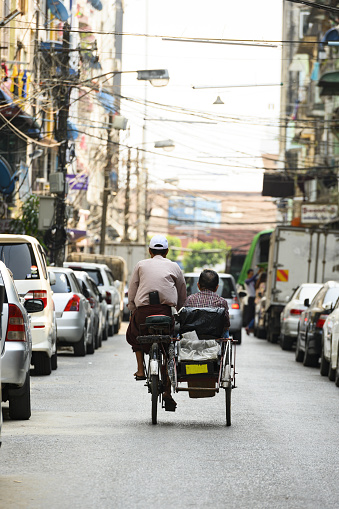 Yangon, Myanmar, March 17, 2019. A unidentified Sai Kaa driver is carrying a passenger on his side car among the narrow streets of Yangon, Myanmar. The Sai Kaa rickshaw is a type of tricycle designed to carry passengers on for hire basis and is widely used in southeast Asia.
