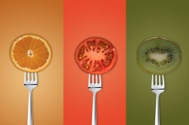 Fruits and vegetables on the forks over colored background