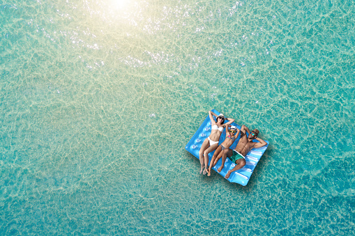 Happy family on inflatable bed on the sea