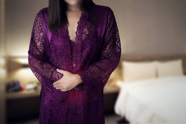Woman in white silk nightgown and lace robe with uterus pain at night. inflammatory bowel disease. People having stomach ache Woman in white silk nightgown and lace robe with uterus pain at night. inflammatory bowel disease. People having stomach ache HPV Symptoms in Women stock pictures, royalty-free photos & images