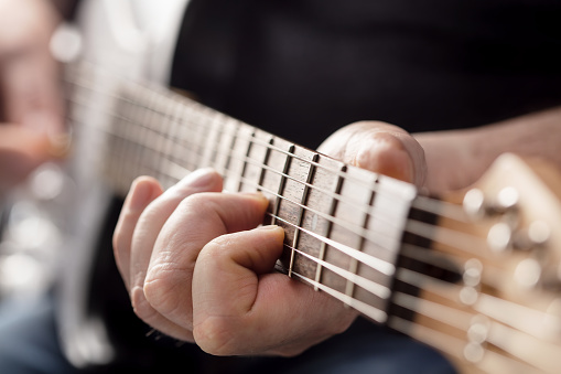 close-up of male hands playing electric guitar