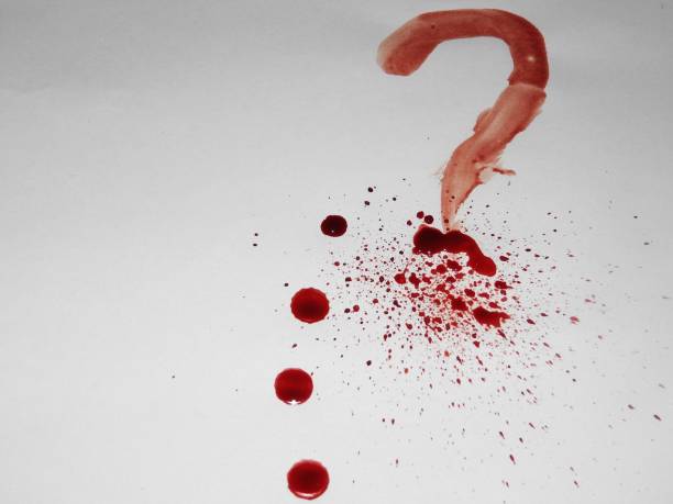 istock Spots and drops of fresh blood on a white background and a question mark. 1139247105