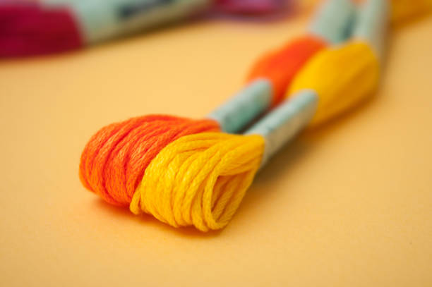 istock colorful cotton threads on yellow background 1139250895