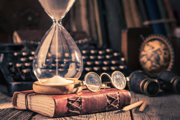 istock Hourglass and journal with compass and binocular 1139251048